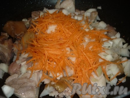 Лук и морковь очистить. Лук нарезать кубиками, морковь натереть на тёрке, добавить овощи к кусочкам свиной рульки и, помешивая, жарить 5 минут, затем посыпать чёрным молотым перцем. 
