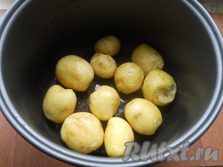 Молодой картофель поскрести, хорошо помыть. Влить в чашу мультиварки растительное масло, выложить картошку в один слой.

