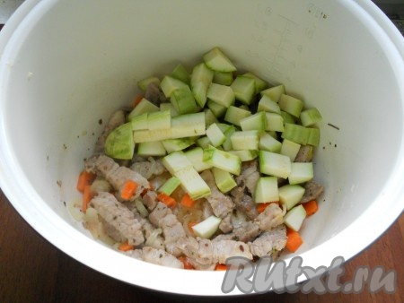 Также добавить морковь, нарезанную кубиками. Продолжать готовить на том же режиме еще 5 минут с открытой крышкой, иногда перемешивая. Затем добавить в чашу нарезанные средними кубиками кабачки.
