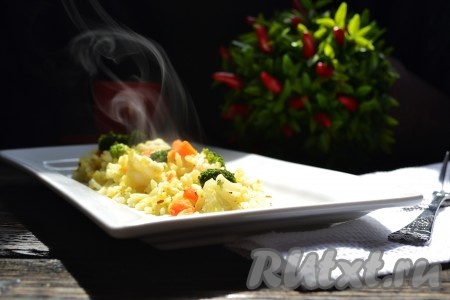 Рис, приготовленный в мультиварке с замороженными овощами, получается аппетитным, ярким, вкусным. Можно подавать на стол.
