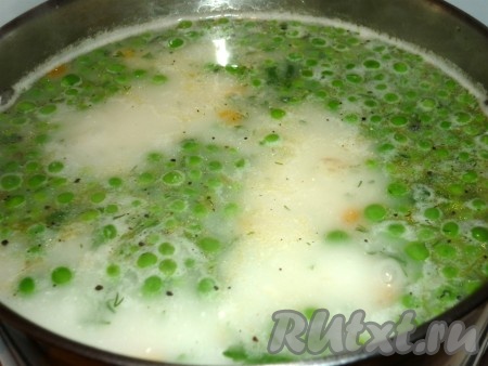 Затем в суп с зелёным горошком добавить сыр, нарезанный кубиками или натёртый на тёрке, и мелко нарезанную зелень. Проварить суп еще пару минут, иногда помешивая, чтобы сыр растворился. Когда суп станет молочного цвета, можно снимать с огня. 
