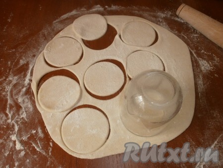 Стол посыпаем мукой и раскатываем тесто в форме круга, из которого выдавливаем стаканом заготовки для вареников.