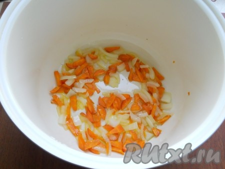В чашу мультиварки налить растительное масло и выставить на 20 минут программу "Жарка". Через 5 минут после начала программы выложить в чашу морковь и лук, обжаривать 10 минут, иногда помешивая.
