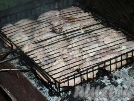 Свинину достать, освободить от лука, чтобы он не подгорел. Лук мы всегда жарим отдельно, после того как пожарим шашлык. Решетку-гриль смазать немного растительным маслом и выложить на неё мясо. 
