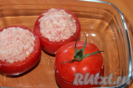 Готовые фаршированные помидоры поместить в жаропрочную форму, накрыть "крышечками". На дно формы налить немного холодной воды. Поставить форму с помидорами в разогретую до 190 градусов духовку и запекать примерно 30-35 минут.
