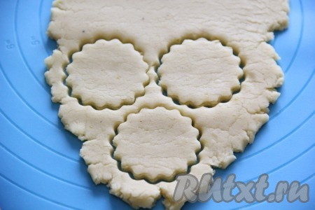 Раскатать тесто на столе присыпанном мукой или на силиконовом коврике в пласт толщиной примерно 0,5 см и с помощью формочек вырезать печенье.