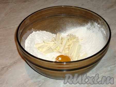 Холодное сливочное масло порубить ножом и добавить в миску к остальным ингредиентам. Растереть тесто в крошку между ладонями.