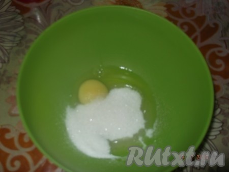 Берём объёмную миску, вбиваем в неё яйцо и насыпаем сахар, взбиваем венчиком до получения однородной массы.