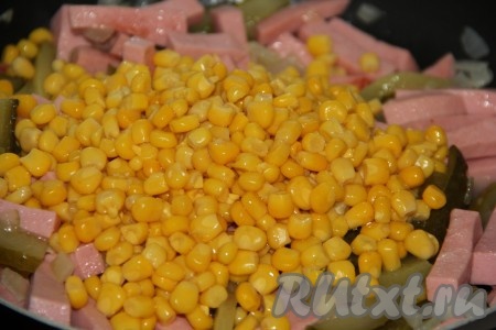 С кукурузы слить лишнюю жидкость. Выложить кукурузу в сковороду, хорошо перемешать начинку, можно слегка подсолить.
