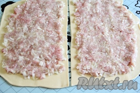 Разрезать пласт теста на две части. Выложить мясную начинку на тесто и аккуратно её разровнять, оставляя края теста пустыми.