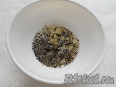 Чеснок мелко нарезать, добавить растительное масло, соль, перец душистый, майоран и базилик, перемешать.
