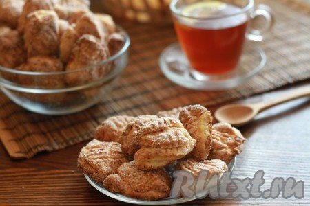 Достаньте нежное, вкусное, хрустящее творожное печенье "Гусиные лапки" и выложите на тарелочки.