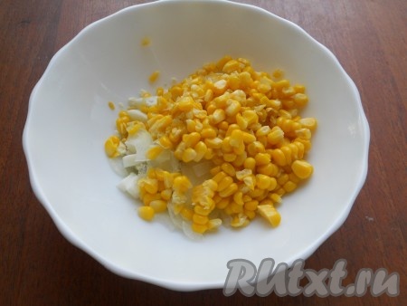 Зерна кукурузы (если кукуруза свежесваренная - срезать зёрна с кочана) добавить к нарезанным яйцам и луку.
