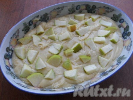 Форму для выпечки смазать сливочным маслом и выложить в нее тесто. Сверху - нарезанные яблоки, предварительно очищенные от семян.