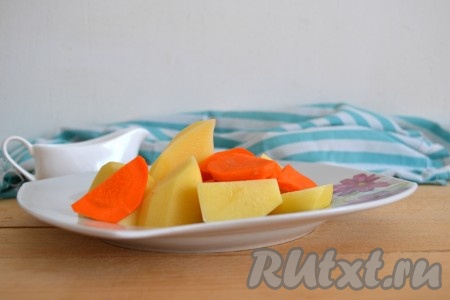 Очистить картофель и нарезать на 4 части. Морковь очистить и нарезать полукольцами. Овощи посолить, поперчить по вкусу и выложить плотно в брюшко утки. Оставшиеся овощи выложить на дно формы для запекания.