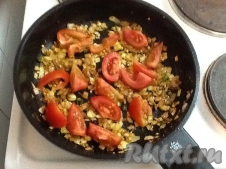 Потушить пару минут и добавить помидоры и, если есть, листья кинзы. Готовить еще 2-3 минуты, иногда помешивая.
