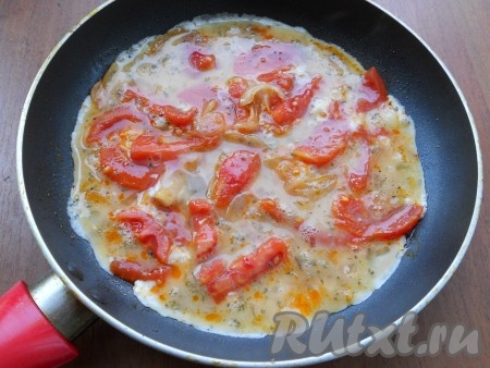 Обжарить лук с помидорами 2-3 минуты на среднем огне, помешивая. Яйца расколотить вилкой и вылить их в сковороду.