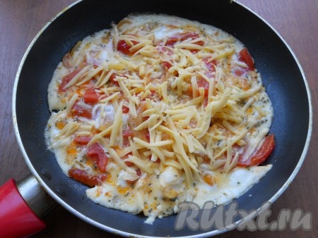 Сковороду прикрыть крышкой и готовить яичницу с помидорами и луком 3-4 минуты. Далее посыпать яичницу сверху тертым сыром, прикрыть крышкой и выключить газ.
