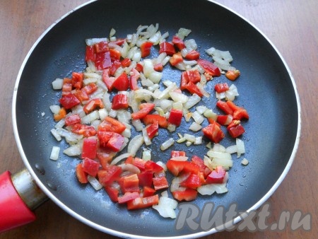 Добавить к луку очищенный от семян и нарезанный кубиками сладкий болгарский перец, обжаривать 2-3 минуты, помешивая.
