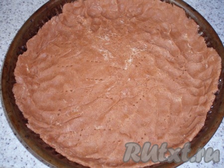 Охлажденное тесто раскатать, выложить в форму для выпечки, формируя бортики. Запечь в разогретой духовке при температуре 180 градусов в течение 15-20 минут.
