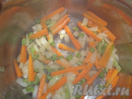 Лук и сельдерей нарезать достаточно мелко.  Морковь нарезать брусочками. В кастрюле нагреть растительное масло, обжарить морковку, лук и сельдерей, иногда помешивая, в течение нескольких минут. Посолить.
