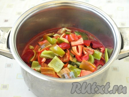 В горячее томатное пюре погрузить перцы и продолжать варить. Когда перец немного обмякнет, добавить в кастрюлю сахар и соль, перемешать.

