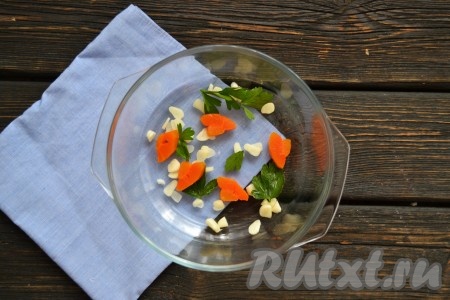 По мисочкам разложить мелко нарезанный чеснок и небольшие кусочки сваренной моркови. По желанию выложить по несколько листиков петрушки. 