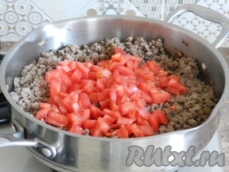 Когда фарш обжарится, то есть сырых кусочков мяса совсем не будет видно, добавить в сковороду помидоры. Перемешать и готовить вместе 10 минут, иногда помешивая.
