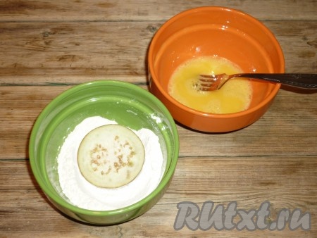 Яйцо взбить вилкой до однородной массы с щепоткой соли. В отдельной мисочке подготовить муку. Обвалять каждую заготовку из баклажанов с фаршем в муке, а затем обмакнуть в яйцо. 
