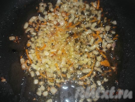 Ставим сковороду на средний огонь, наливаем растительное масло и обжариваем мелко нарезанный лук и натёртую морковь до золотистого цвета, иногда помешивая.
