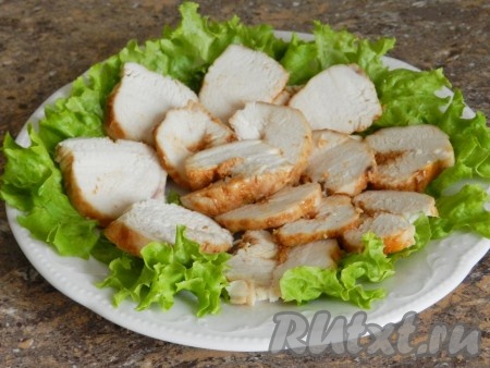 Куриное филе нарезать и выложить на салатные листья.