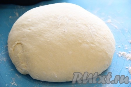 Дрожжевое тесто, подошедшее в хлебопечке или в тёплом месте, выложить на стол, присыпанный мукой, или на силиконовый коврик и хорошо обмять.