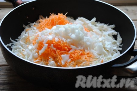 На сковороде разогреть небольшое количество растительного масла, выложить капусту, морковь и лук, перемешать. 
