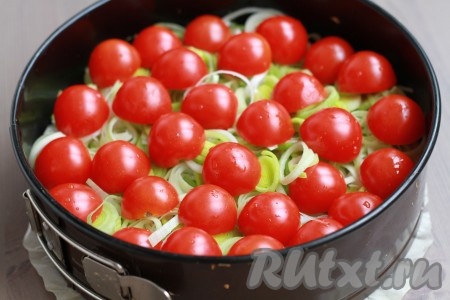 На лук выложить помидоры черри, разрезанные на половинки.
