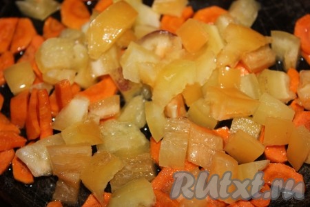 Болгарский перец вымыть, очистить от семян и плодоножки, нарезать средними кубиками и отправить в сковороду к моркови. Обжаривать овощи в течение 2-3 минут, периодически помешивая.
