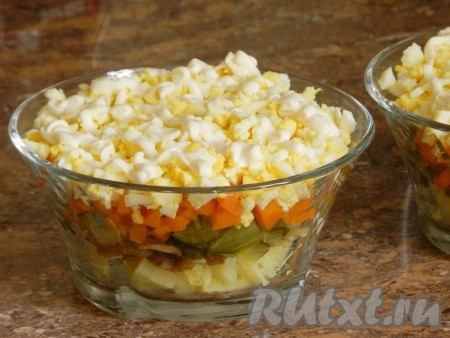 Выложить яйца поверх моркови и покрыть сеткой майонеза.