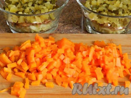 Затем нарезать кубиками отваренную морковь и добавить в салат следующим слоем.