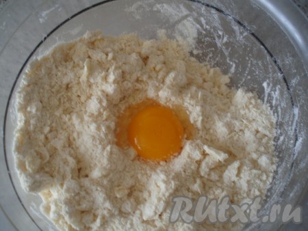Муку и сахарную пудру просеять со щепоткой соли в глубокую миску. Добавить кусочки холодного сливочного масла (или маргарина), перетереть руками до образования крошки. Добавить 1 яичный желток.