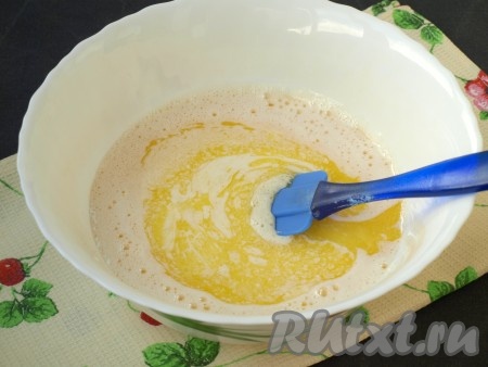 Добавить в миску кефир и растопленное остывшее сливочное масло, хорошо размешать лопаткой.
