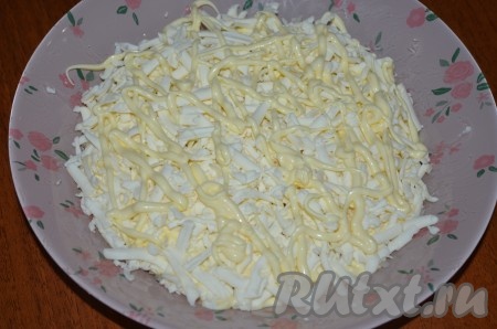 Третий слой - плавленный сыр, натертый на крупной терке, + сеточка майонеза. Чтобы сыр лучше натирался, его можно немного подморозить в морозильной камере.
