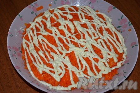 Четвертый слой - морковь, натертая на крупной терке, + сеточка майонеза.
