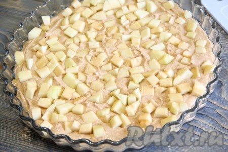 Выложить кусочки яблок поверх теста и слегка их вдавить в тесто.