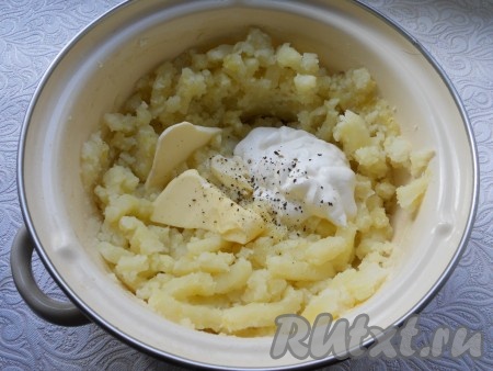 В горячий толченый картофель добавить сливочное масло и сметану, чуть поперчить.
