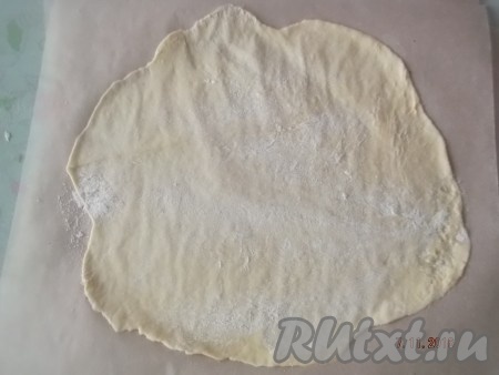 Начинаем печь коржи. Берем пергаментную бумагу, достаём кусочек тесто из холодильника и раскатываем на бумаге в тонкий пласт толщиной 1-2 мм.
