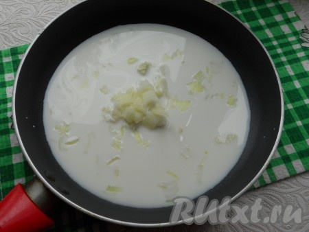 В сковороду влить молоко, добавить соль, довести молоко до кипения и добавить мелко нарезанный лук.
