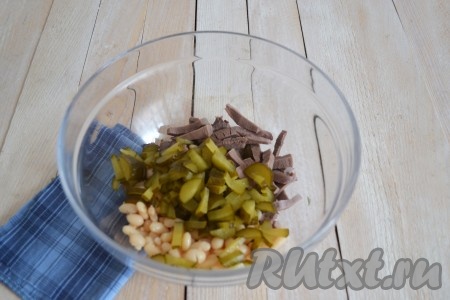 Бочковой кисленький огурец (можно заменить свежим или консервированным) нарезать соломкой и выложить в салат с языком и фасолью.
