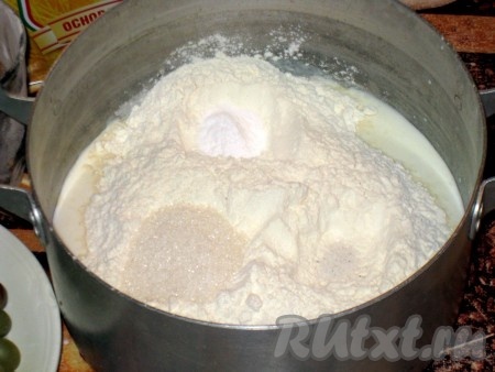 В кастрюльку (или миску) вылить кефир, высыпать муку, добавить сахар, соль и соду. Соду гасить не нужно, она погасится кефиром.
