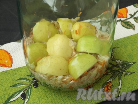 В чистую стерильную банку сложить слой капусты, затем - слой яблок срезом вниз.
