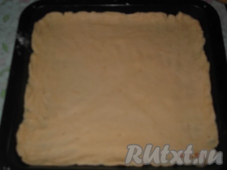 Берем наше тесто и разделяем его на 2 части. Каждую часть раскатываем в тонкий пласт толщиной, примерно, 3-4 мм. Выкладываем на противень, смазанный маслом, первую раскатанную часть теста.  
