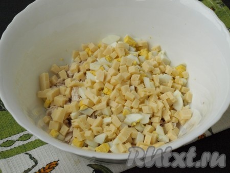 Твёрдый сыр (немного сыра оставьте для украшения салата) и очищенные яйца нарезать кубиками и выложить к куриному филе. 